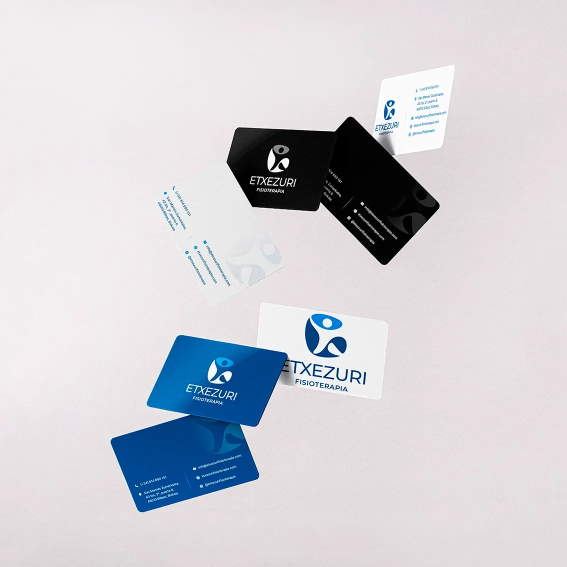 Floating Etxezuri Fisioterapia business cards in blue, white and black with the figure logo and Bilbao contact details, corporate identity design