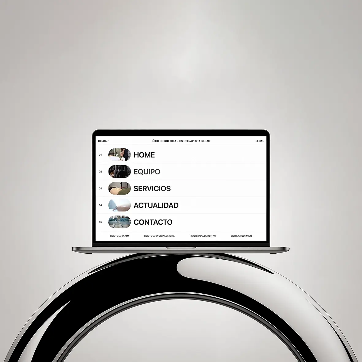 Iñigo Goikoetxea physiotherapist Bilbao website shown on a laptop with a thumbnail menu, over a black-and-chrome sculpture.