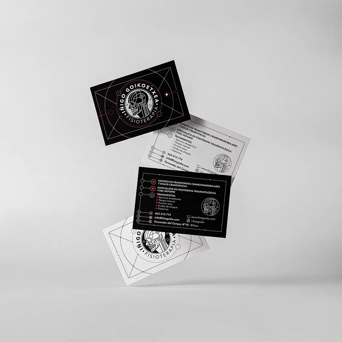 Business cards for Iñigo Goikoetxea Fisioterapia floating on a grey background, with an anatomical skull logo in black, white and red